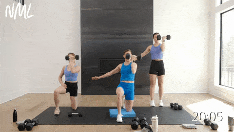 two women performing a kneeling single arm shoulder press and one woman performing a standing single arm shoulder press in an arm workout with dumbbells