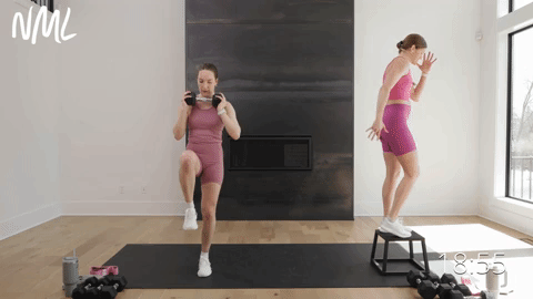 two women performing a reverse lunge in a leg workout at home