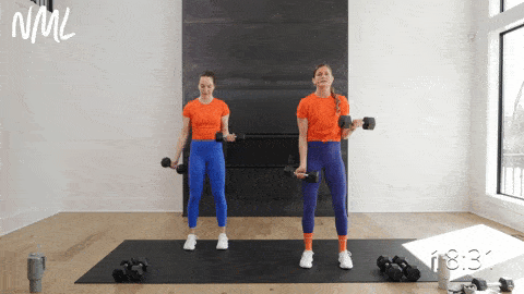 two women performing a single arm bicep curl and isometric hold in an upper body pull workout at home
