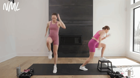 two women performing a single leg plyometric lunge in a leg workout