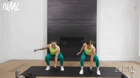 two women performing a squat pulse and single arm snatch in a full body endurance workout