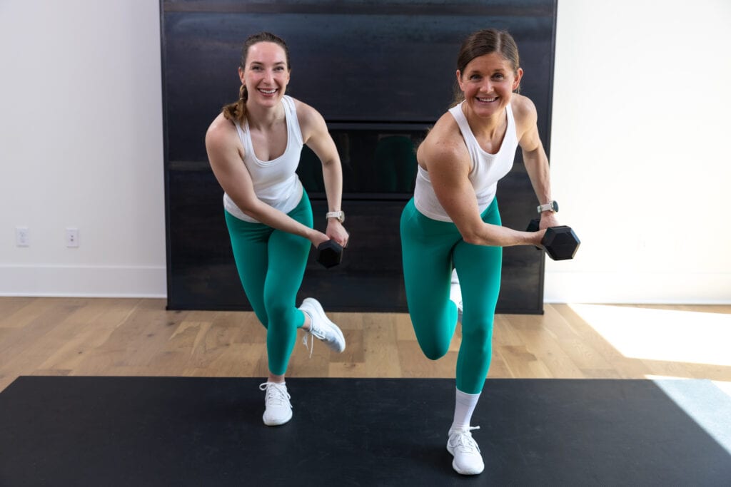 two women performing dumbbell skaters as part of sweaty abs standing workout