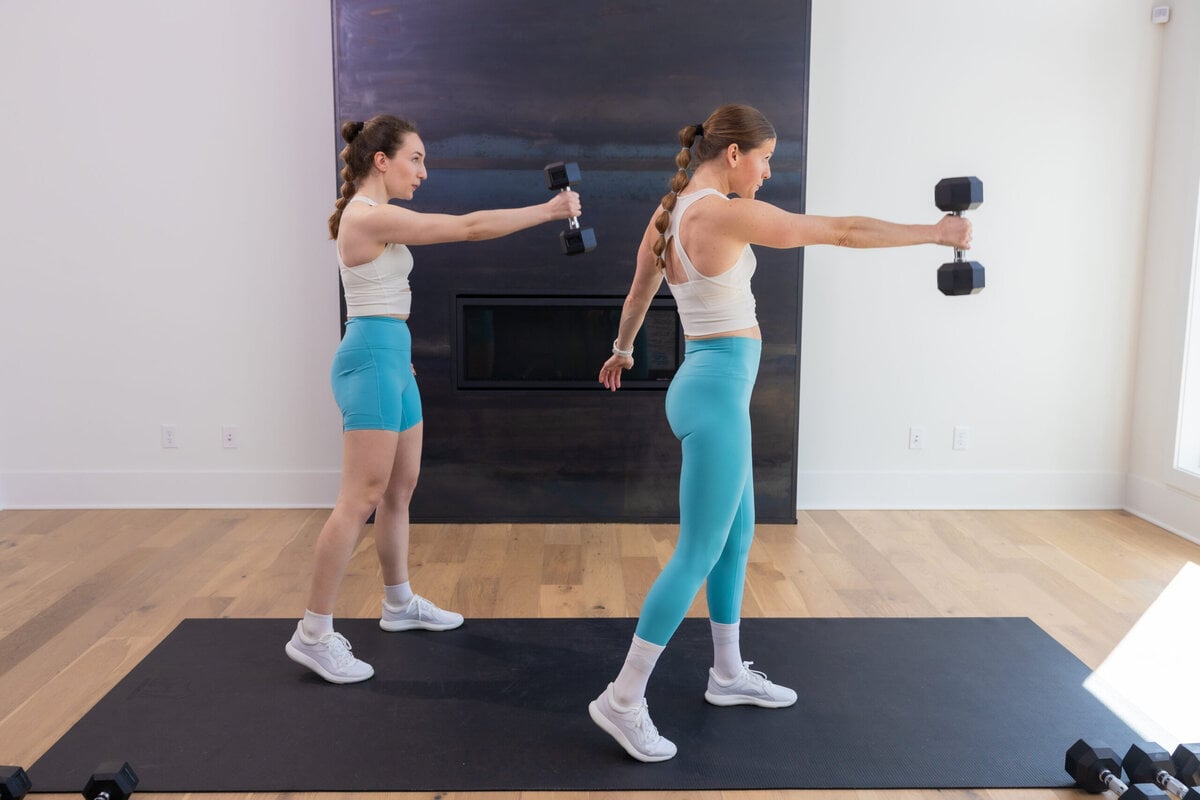 Two women performing a dumbbell swing as part of full body workout