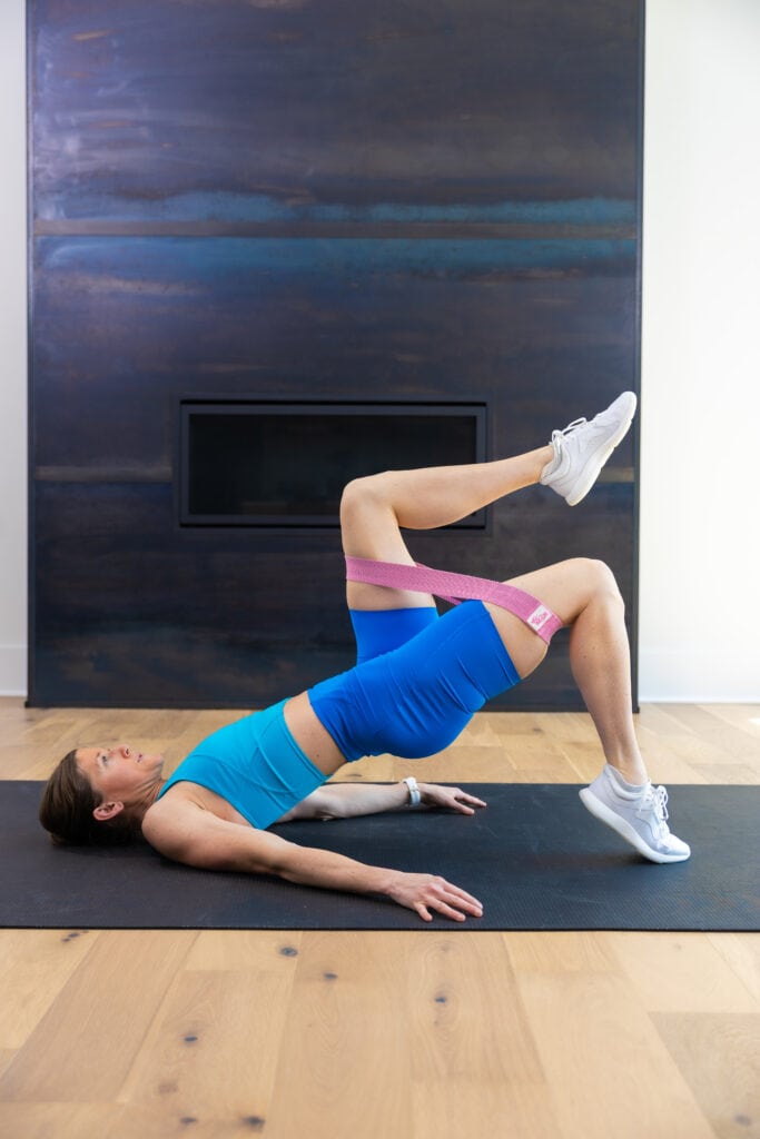 Woman performing a single leg glute bridge with calf raise as example of eccentric leg exercise