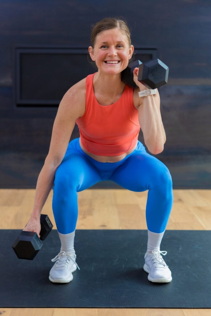 woman performing an uneven rack front squat as part of cardio and strength training workout