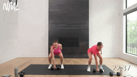 two women performing a lateral squat push and dumbbell pick up as a cardio exercise in a HIIT workout