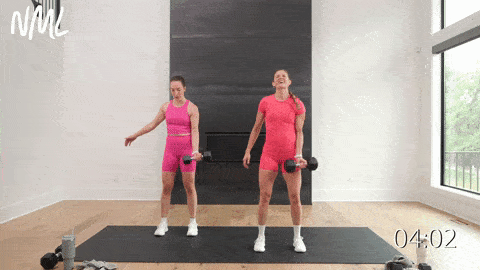 two women performing a single arm bicep curl with a heavy dumbbell in a HIIT workout with weights