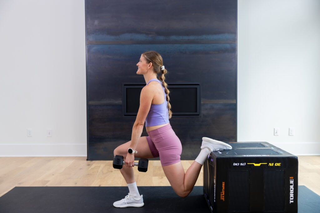 Woman performing a rear foot elevated split squat (bulgarian split squat) as part of quad workout