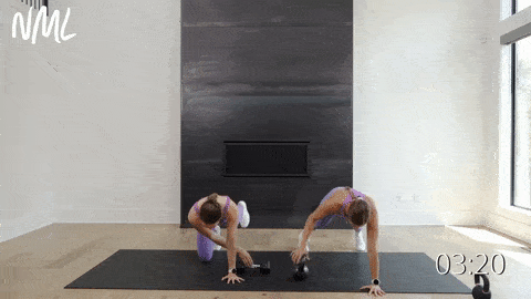 two women performing a kettlebell bear crawl pull through as part of kettlebell abs routine