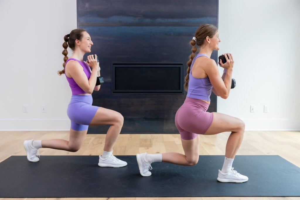 two women performing a front lunge as part of quad workout at home