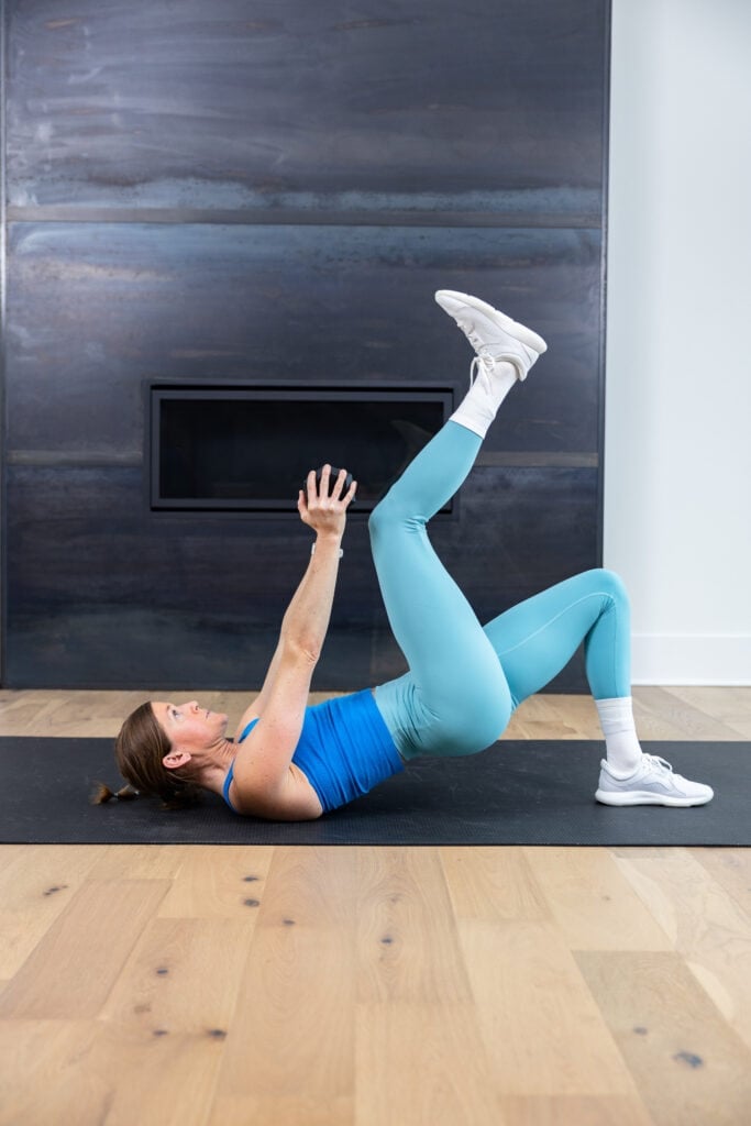 woman performing a glute bridge march as example of unilateral ab exercise