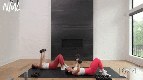 two women performing a chest press as part of arm workouts at home