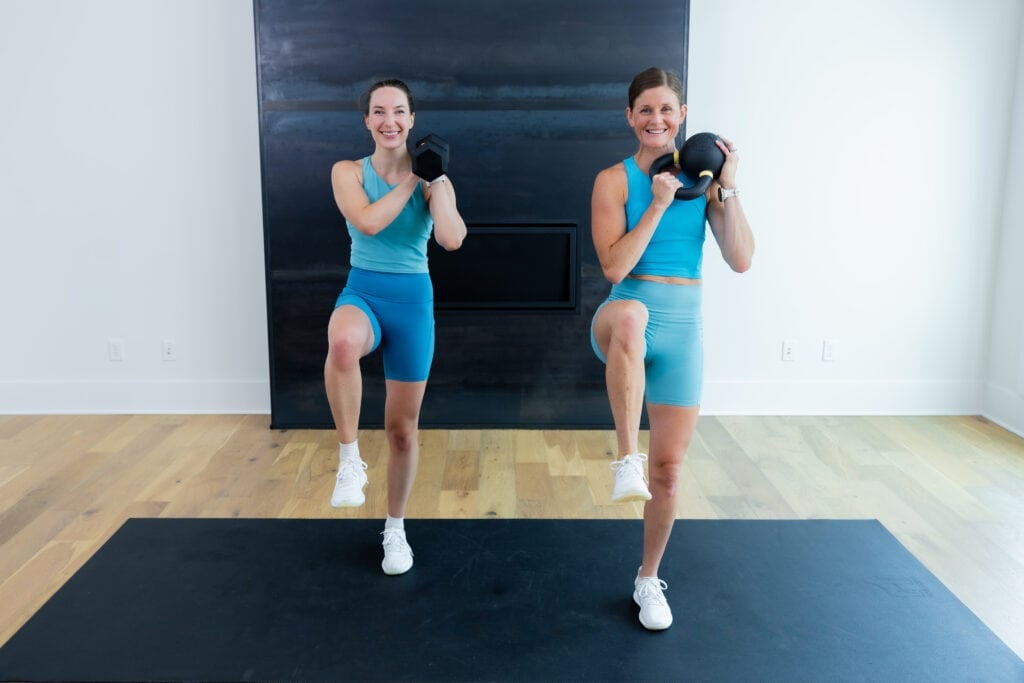 two women performing a kettlebell clean and uneven march as part of a full body kettlebell workout