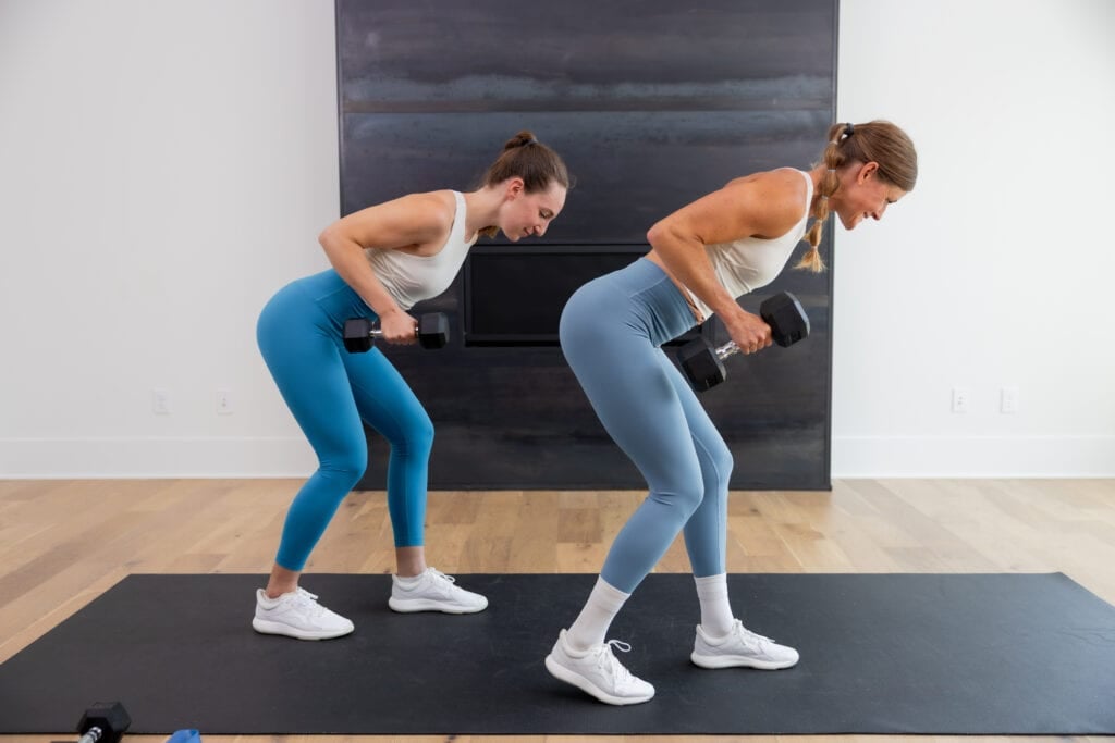 two women performing single arm tricep kickbacks in a tricep workout at home