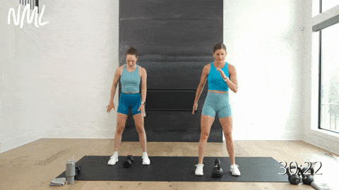 two women performing a kettlebell  squat and pick up in a full body hiit workout