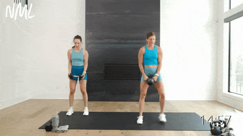 two women performing a lateral lunge and bicep curl as part of the best kettlebell exercises for strength