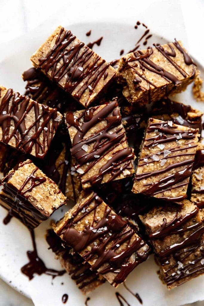 Plate of mini peanut butter protein bars, each bar has 7 grams of protein per serving and 5 grams of sugar. The recipe is dairy free, egg free, gluten free, vegan and vegetarian.