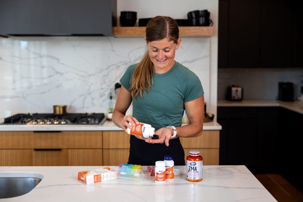 Woman pouring supplements into the palm of her hand as part of review of the best supplements for busy women