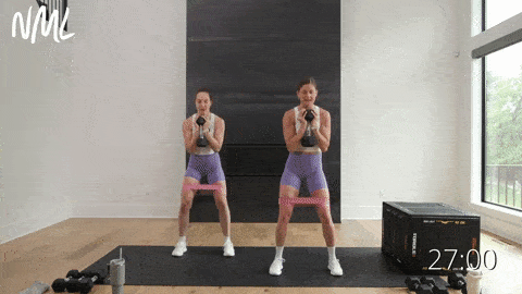 two women performing goblet squats as part of dumbbell leg workout