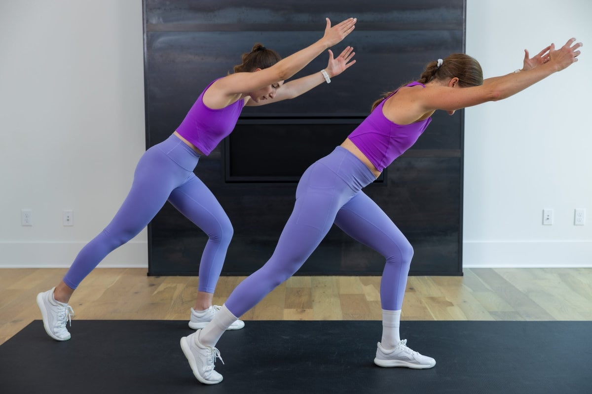 Two women performing a knee drive exercise as part of best at home cardio workout
