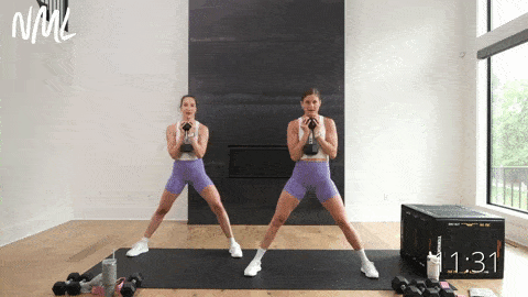 two women performing lateral squats as part of dumbbell leg workout 