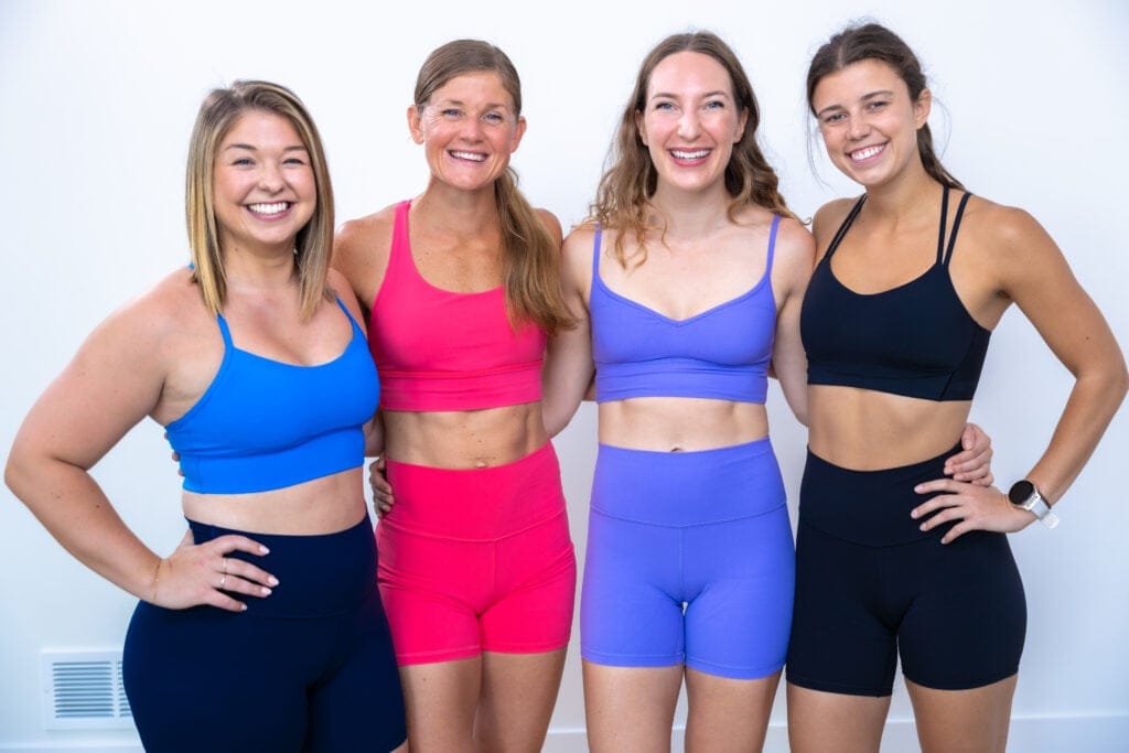four women wearing different lululemon sports bras smiling at camera 
