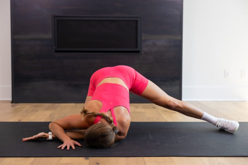 woman performing spinal rotations as part of mobility workout