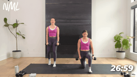 two women performing a front raise as part of yoga sculpt workout