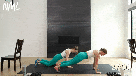 two women performing a push up to downward facing dog in a barre workout
