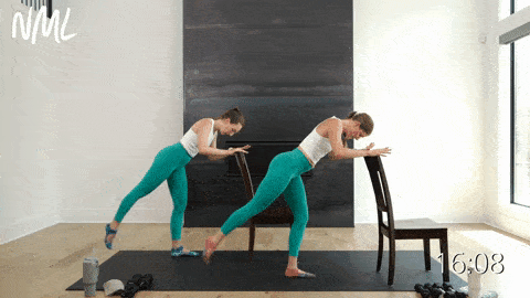 two women performing rear leg lifts and a knee drive scoop using chairs for balance support in a barre workout