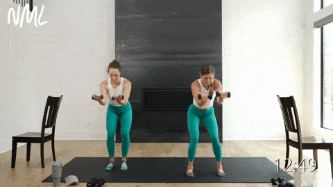 two women performing a curtsy lunge tap back and l-fly with light weights into a narrow squat and press in a barre sculpt workout