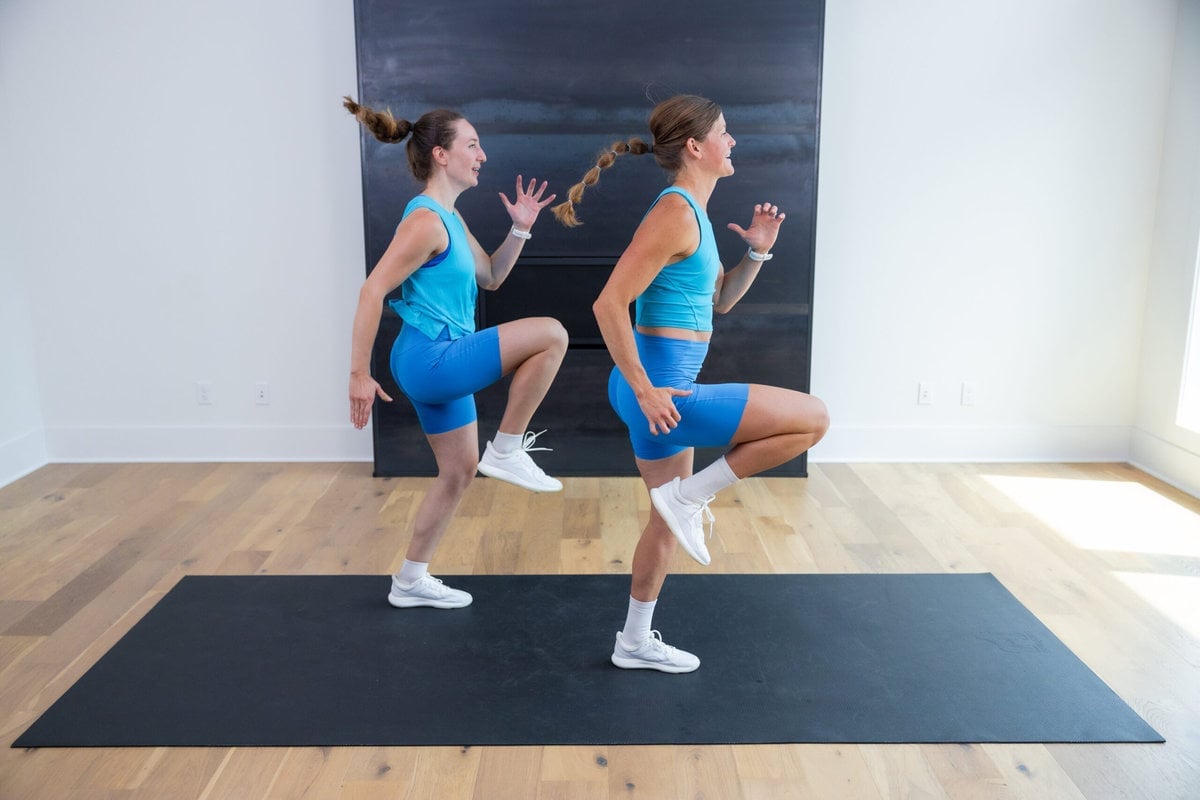 two women performing high knees as part of standing ab circuit workout