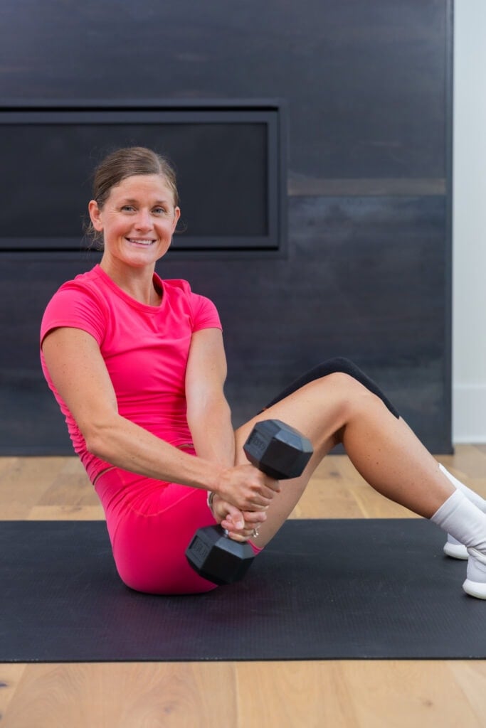 woman performing dumbbell sit up as part of 5-day workout split