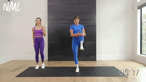 two women performing a lateral lunge and knee drive in a morning workout
