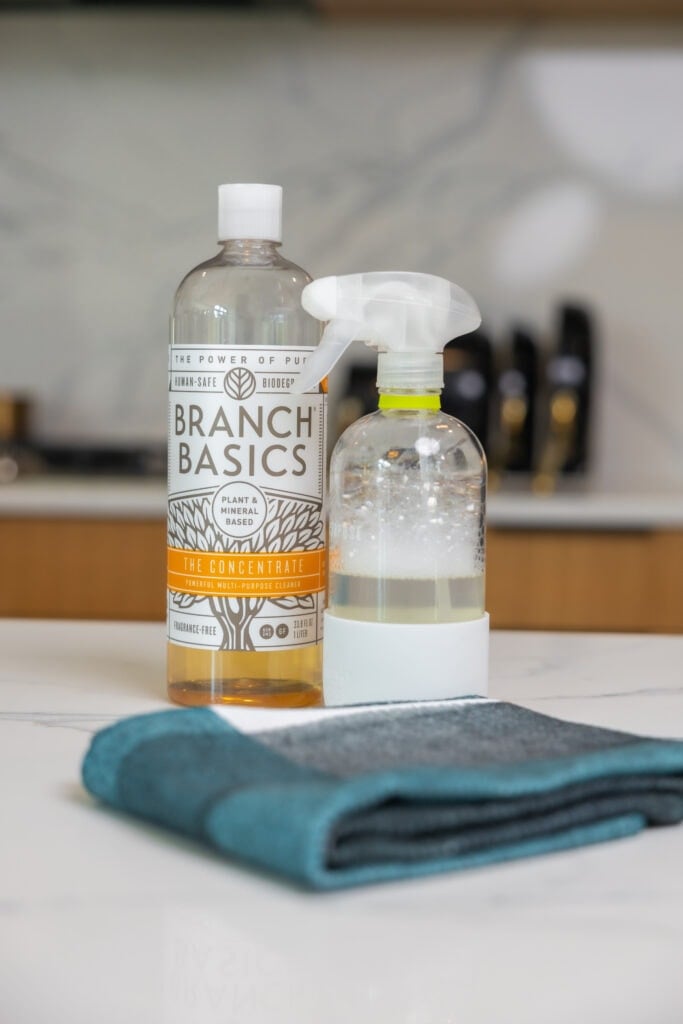 Branch Basics cleaning product and a towel sitting on a kitchen countertop as part of kitchen essentials