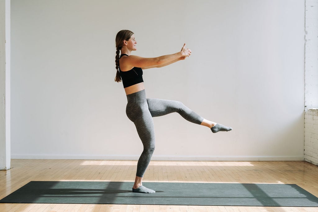 Woman performing a first position leg lift as part of cardio barre burn workout class