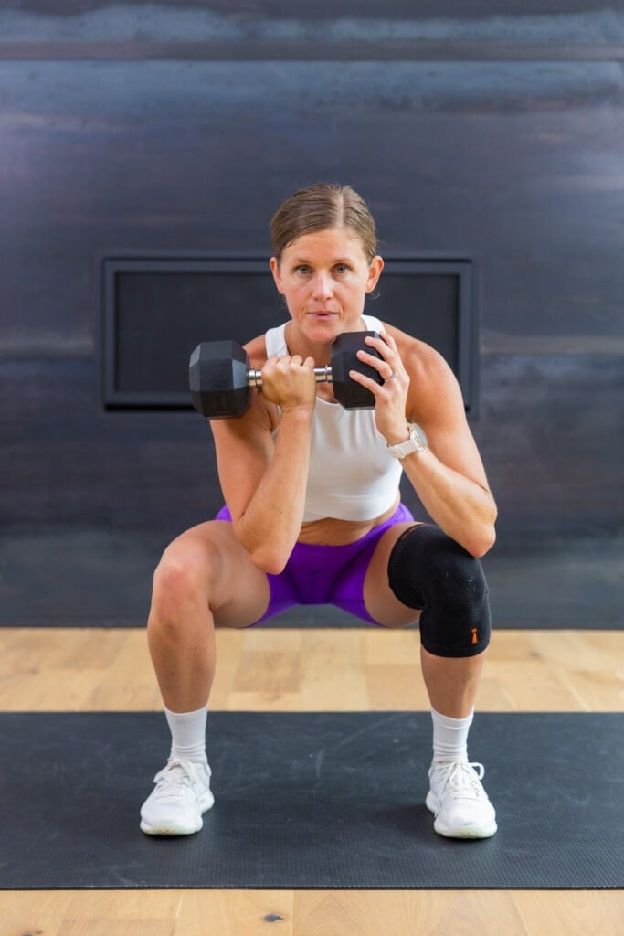 woman performing front rack squat as part of compound training leg day