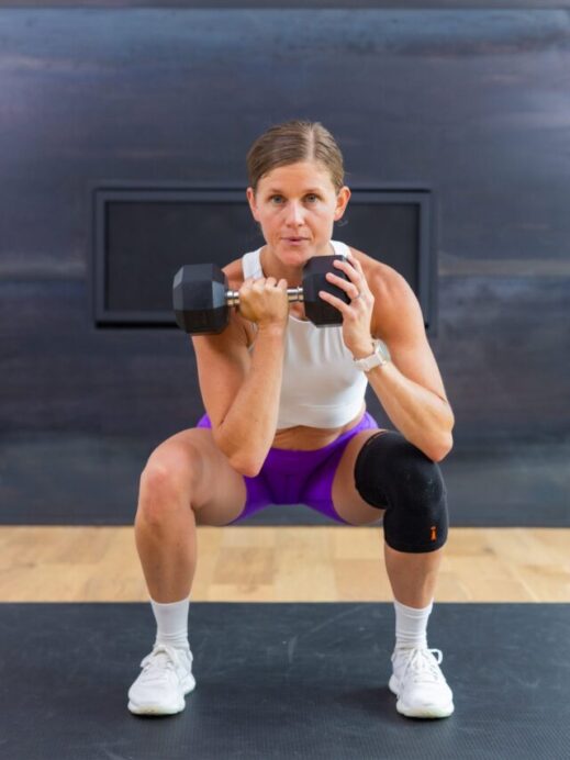 woman performing front rack squat as part of compound training leg day