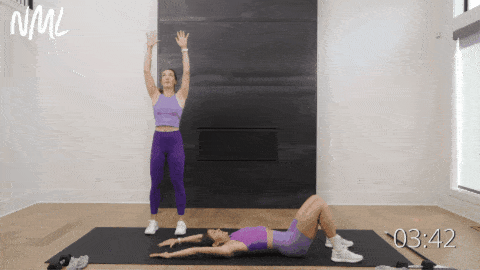two women performing supine snow angels as part of shoulder mobility workout