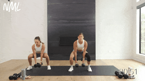 two women performing a side to side squat and clean as example of compound leg exercise