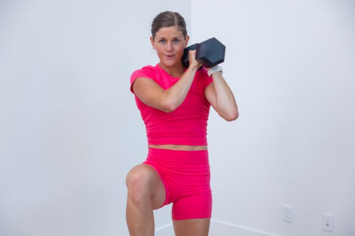 woman performing a single arm rack and knee drive as part of 15 minute workout