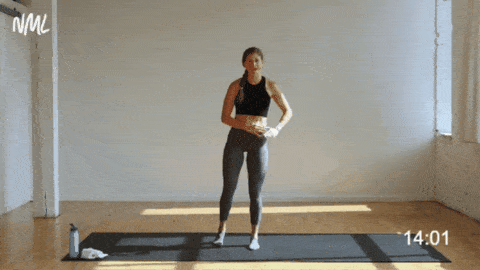 woman performing a staggered squat and leg lift to the side as part of cardio barre workout