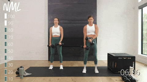 two women performing alternating crossbody bicep curls in an upper body workout