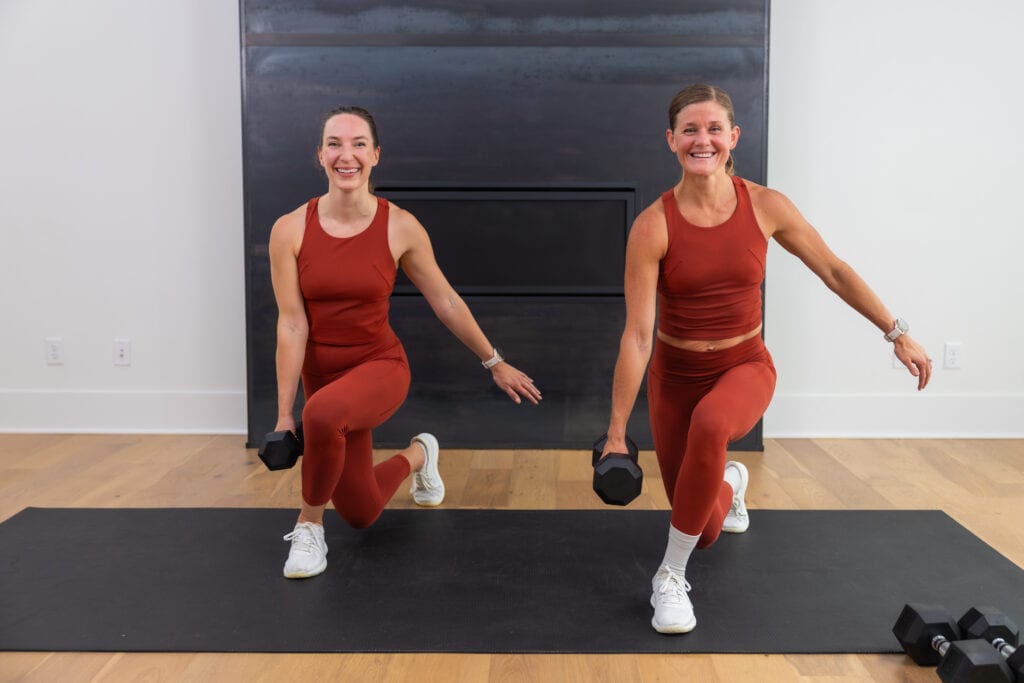 two women performing a curtsy lunge