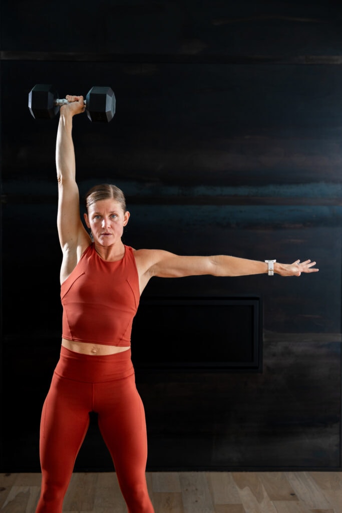 woman performing dumbbell snatches