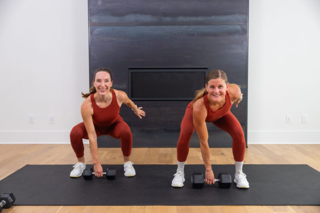two women performing a dumbbell snatch