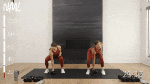 two women demonstrating a dumbbell snatch