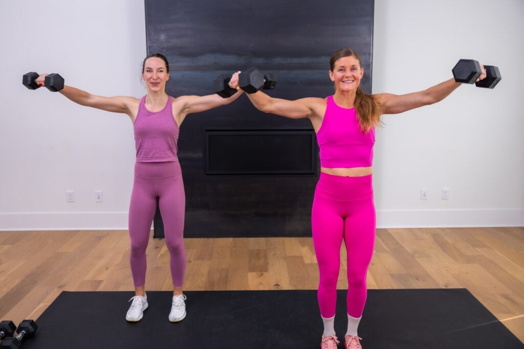 two women performing lat flys as example of full body exercises with dumbbells
