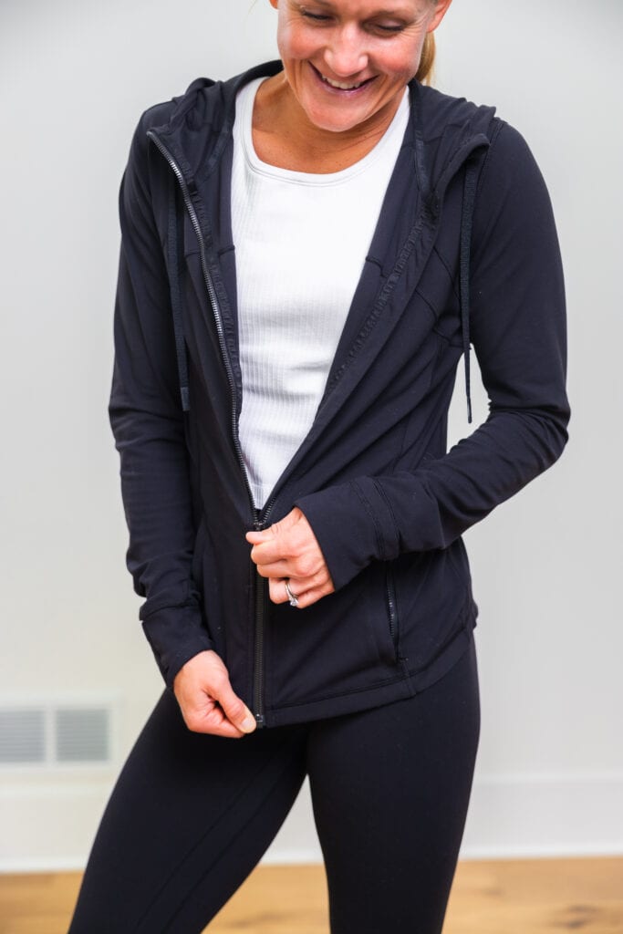 woman zipping up black lululemon define jacket