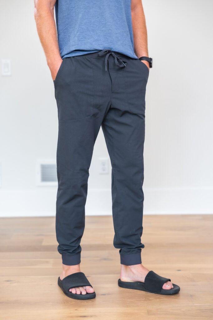 Men wearing lululemon's ABC joggers and blue tank top in color grey. 